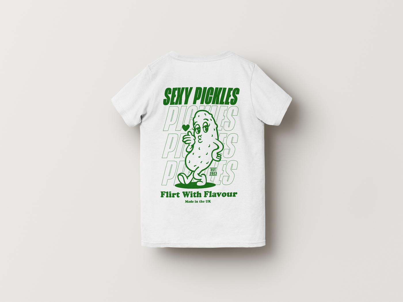 White t-shirt with green graphic and text on a light gray background