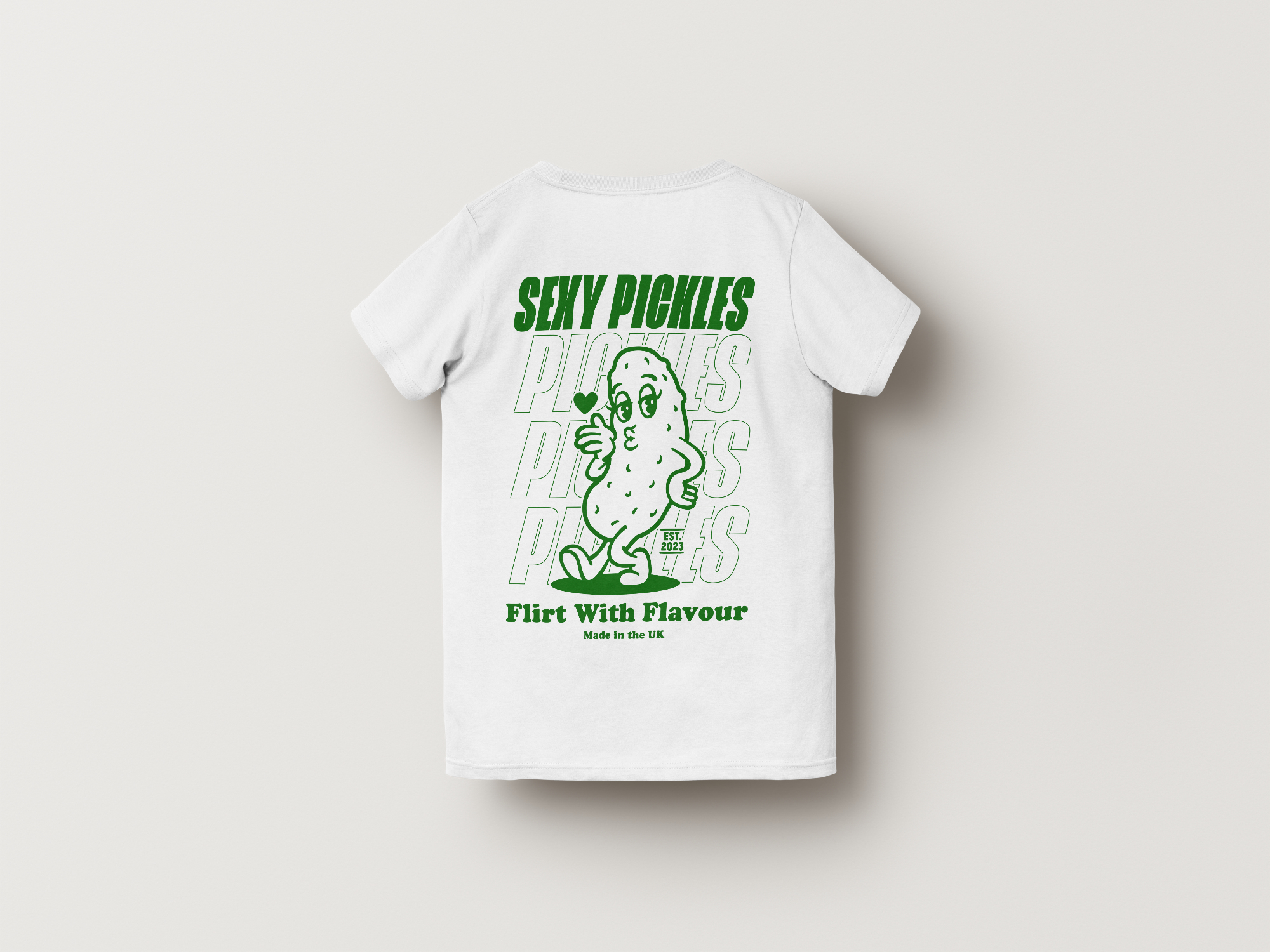 White t-shirt with green graphic and text on a light gray background