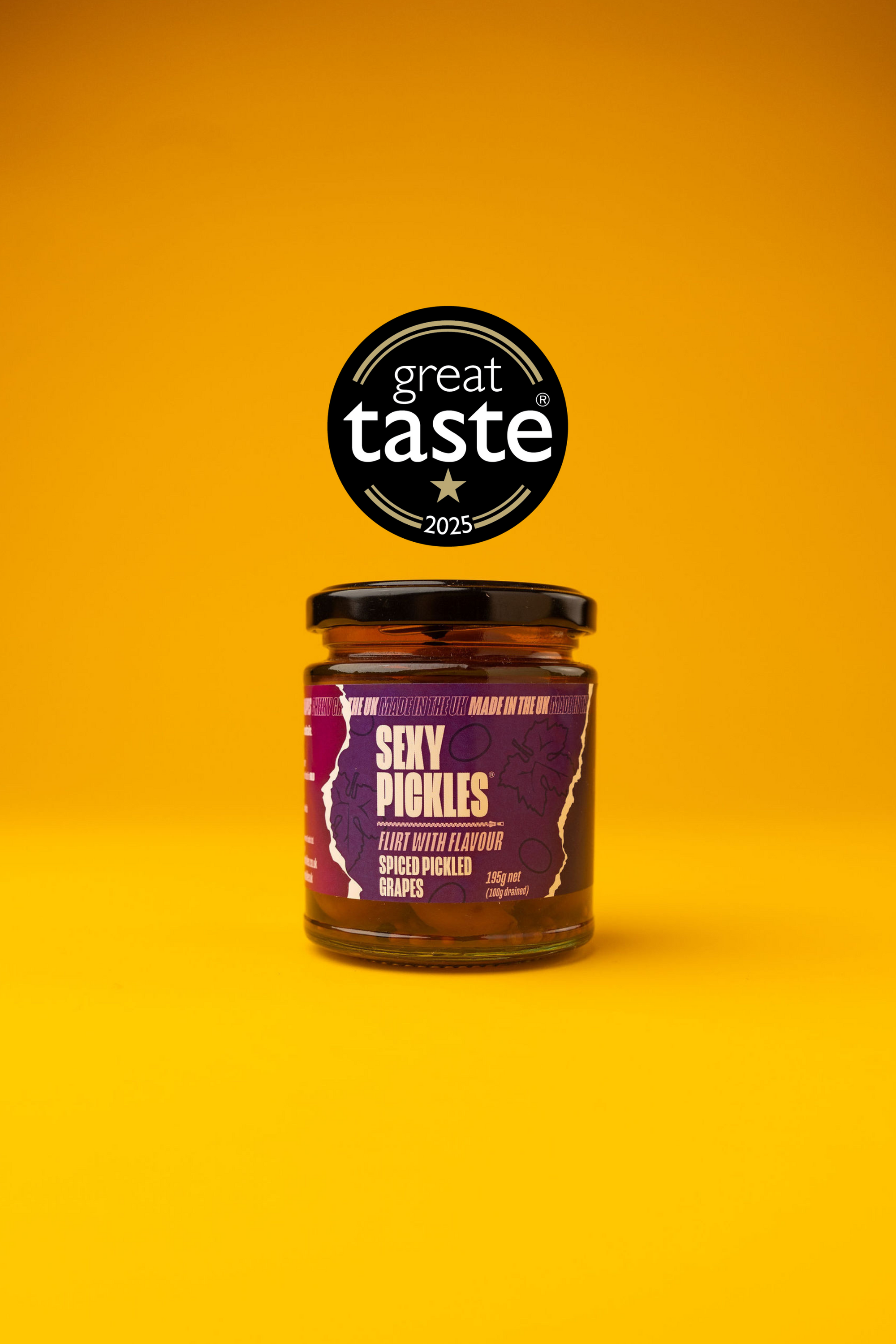 A jar of 'Sexy Pickles' Pickled Grapes a on a yellow background with 'Great Taste' award logo.